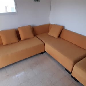 ספות כתומות עם כריות בחדר מואר