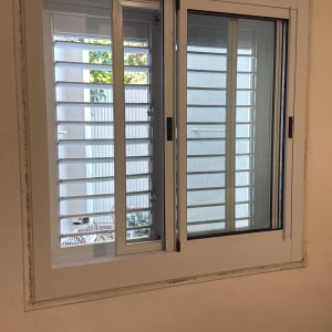 חלון עם תריסים מותקנים על קיר פנימי
