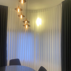 וילונות שחורים ולבנים תלויים על קיר מעוגל