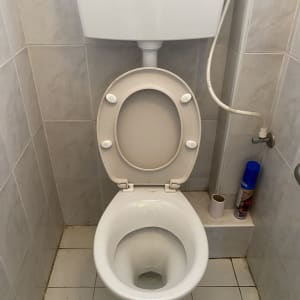 אסלה עם מיכל הדחה וצינור מים