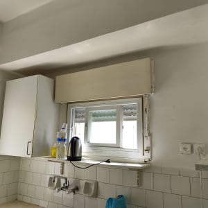 קיר צבוע בלבן עם חלון קטן ומדף