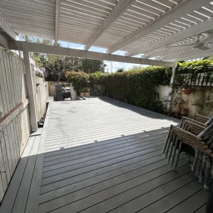 פרגולה מעץ עם דק וגינה מסביב