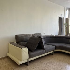 ספה אפורה עם כריות על רצפת אריחים