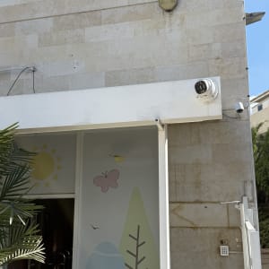 מצלמת אבטחה ומערכת אינטרקום על קיר חיצוני