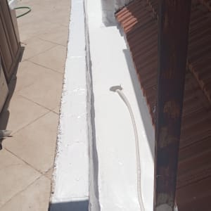 איטום גג עם חומר לבן וצינור פלסטיק