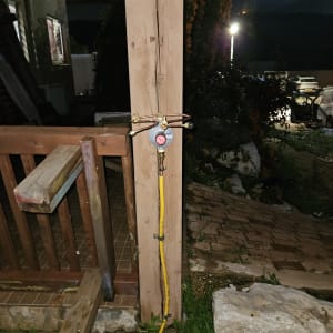 מד לחץ גז צהוב מחובר לעמוד עץ