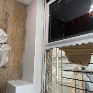 קיר גבס צבוע ליד חלון עם מסגרת מתכת