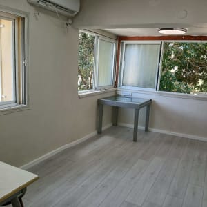 רצפת פרקט בהירה בחדר עם חלונות גדולים