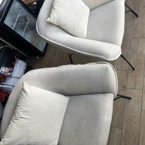 שני כורסאות בד בהירות עם כריות על רצפת עץ