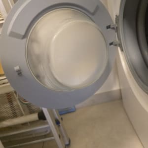 דלת מכונת כביסה פתוחה עם תוף חשוף