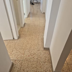 אדם מנקה מסדרון עם רצפת אריחים