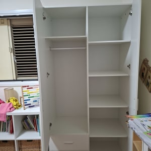 ארון לבן עם מדפים ודלתות פתוחות בחדר ילדים