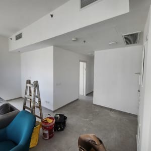 סולם, דלי צבע וכלי עבודה בחדר