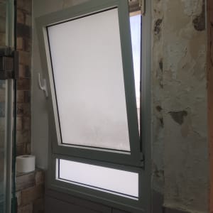 חלון עם תריסים פתוחים למחצה בחדר אמבטיה