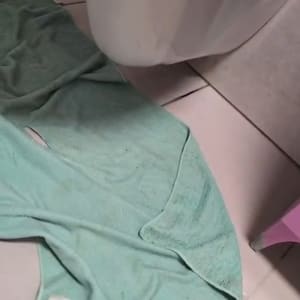 אסלה עם מגבת ירוקה על הרצפה