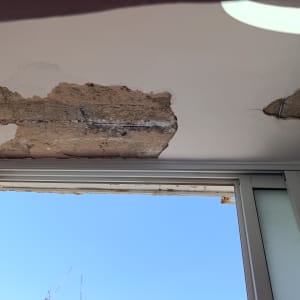 תקרה עם קילופי טיח ליד חלון