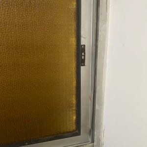 חלון עם זכוכית צהובה במסגרת מתכת
