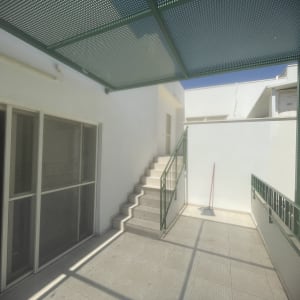 מרפסת עם גג מתכת ומדרגות חיצוניות