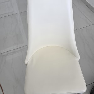 כיסא מרופד בצבע לבן על רצפת אריחים