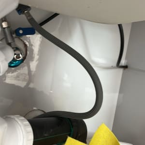 צינור מתכת מתחת לכיור עם ברז סגירה