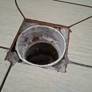 פתח ניקוז ברצפת אריחים עם חור פתוח