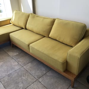 ספה צהובה עם כריות על רצפת אריחים