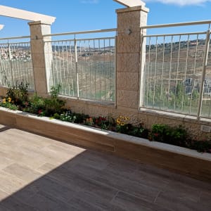 ערוגת פרחים צבעונית על מרפסת עם אדניות