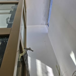 קיר צבוע בלבן עם צללים, סרט דבק על חלון