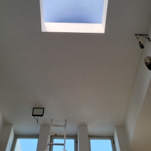 תקרה עם חלון סקיילייט וסולם צבוע לבן