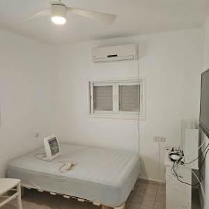 חדר עם מיטה, מאוורר תקרה ומזגן