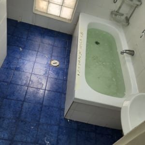 אמבטיה עם מים, אריחים כחולים על הרצפה