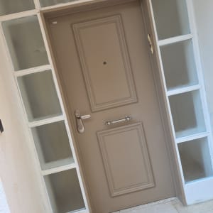 דלת כניסה עם חלונות זכוכית ומנורה תלויה