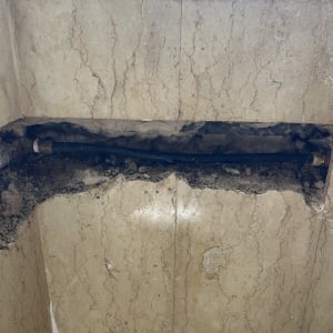 צינור חשוף בקיר עם חיפוי שבור