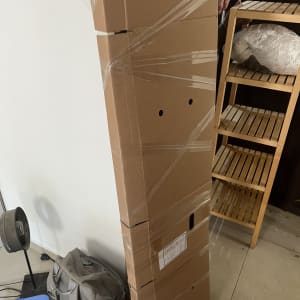קופסה גדולה עטופה בניילון ליד מדף עץ