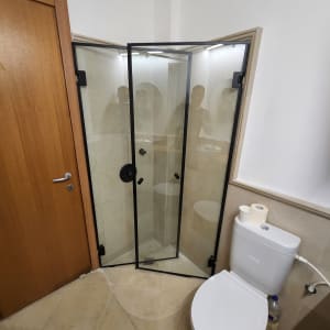 דלת זכוכית למקלחת עם מסגרת שחורה