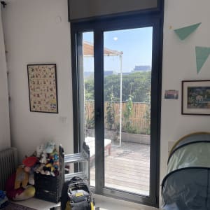 תריסים סגורים מעל דלת זכוכית בחדר מואר