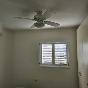 חדר צבוע עם מאוורר תקרה וחלון