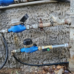 צינורות ומדי מים כחולים על קיר חיצוני