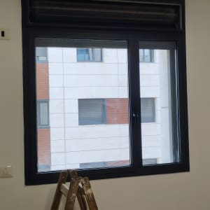 תריסים סגורים מעל חלון זכוכית גדול