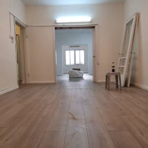 רצפת פרקט עץ בהירה בחדר ריק עם דלתות פתוחות