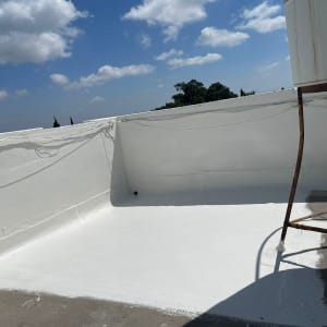 גג צבוע בלבן עם שמיים כחולים ועננים