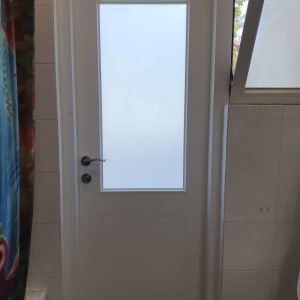 דלת לבנה עם חלון זכוכית מט במרכז