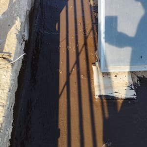 משטח אטום בזפת עם צל של גדר