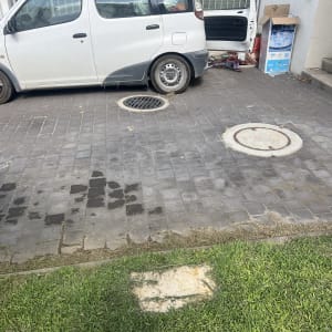 צינור השקיה על דשא ליד רכב חונה