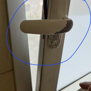 ידית חלון עם סימני שחיקה על הזכוכית