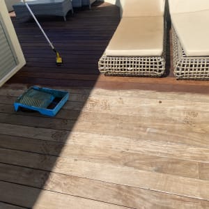 מגש צבע כחול ומברשת על רצפת עץ