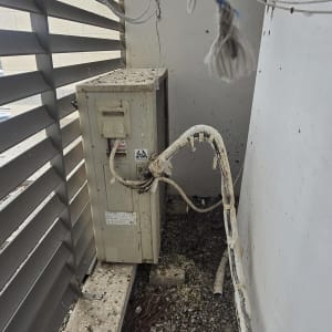 יחידת מזגן מלוכלכת עם חוטים על רצפה מלוכלכת