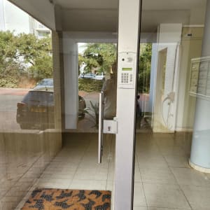 אינטרקום עם לוח מקשים ליד דלת זכוכית