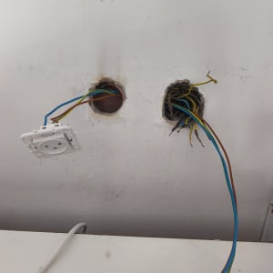 שני חורים בקיר עם חוטי חשמל חשופים