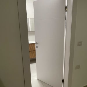 דלת לבנה פתוחה למחצה עם ידית מתכת